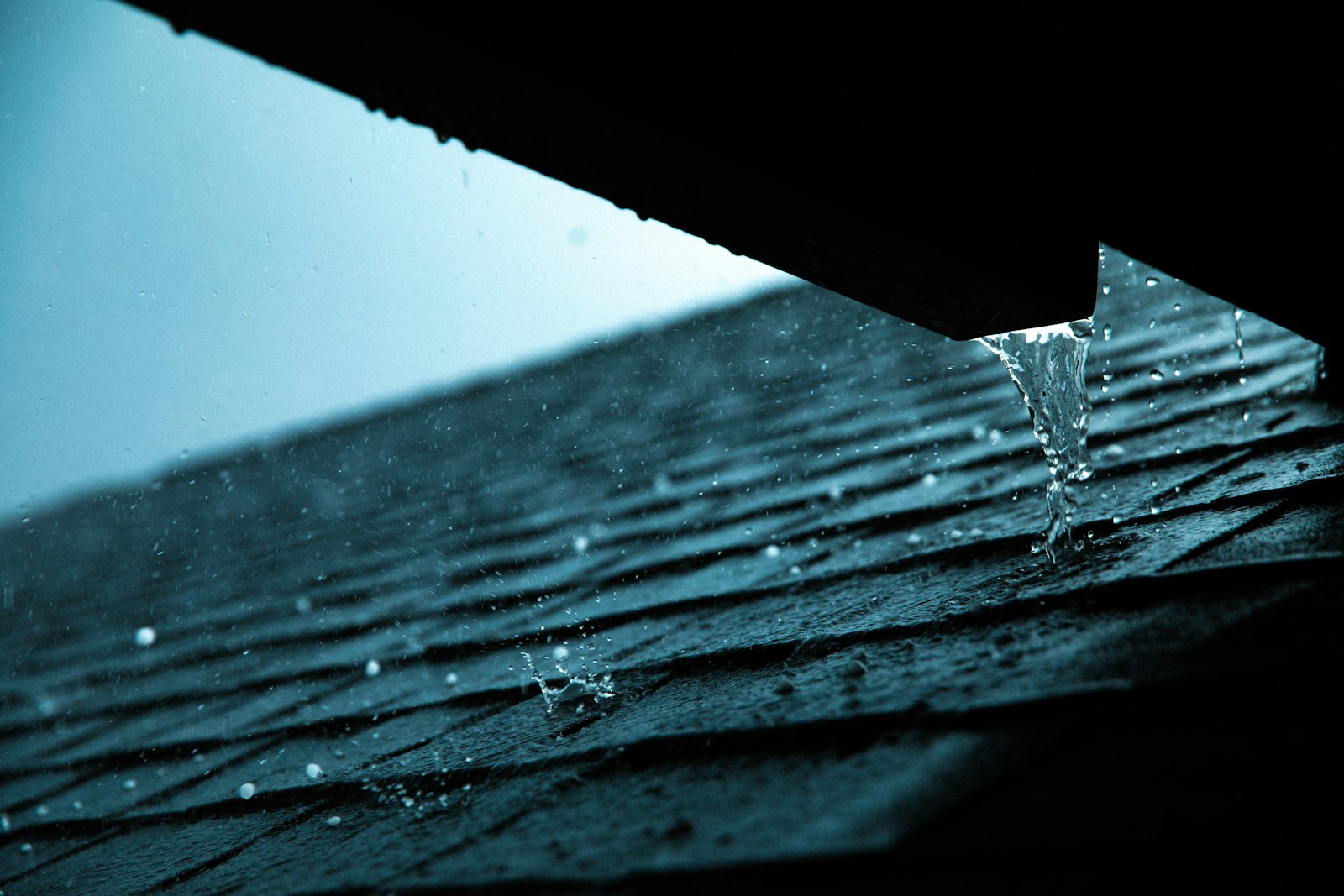 Rain dripping from the edge of a roof gutter