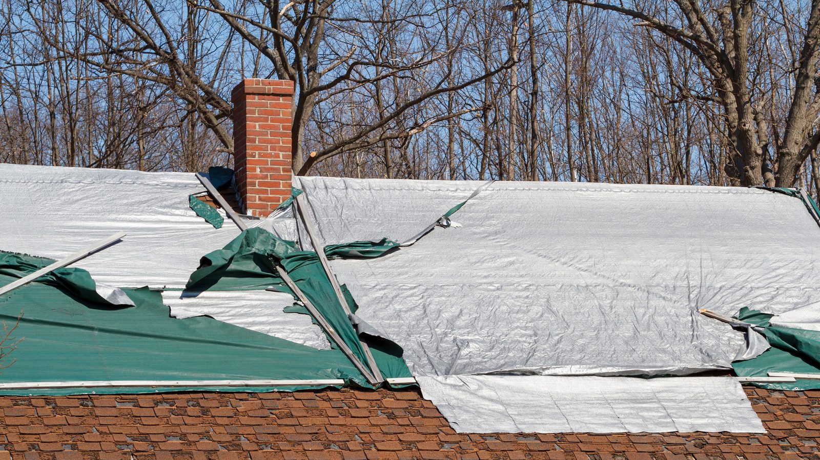 House roof covered with a tarp over a roof leak